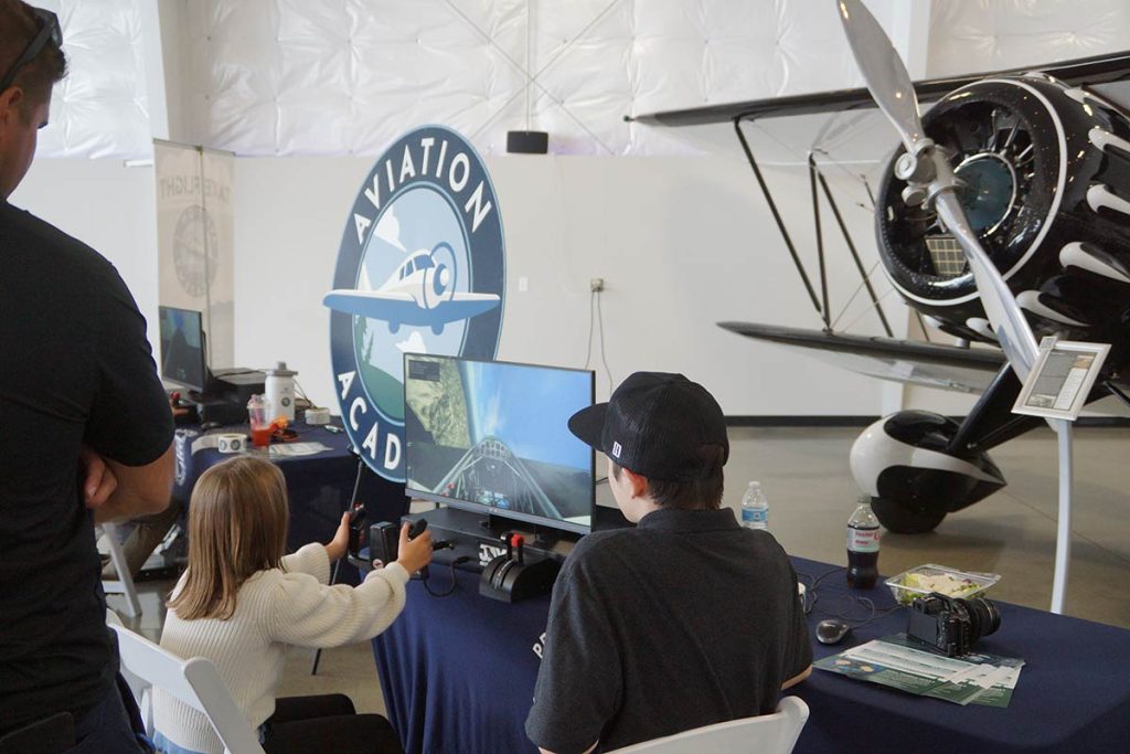 Young girl plays aviation simulator game at the Aviation Academy exhibilt.