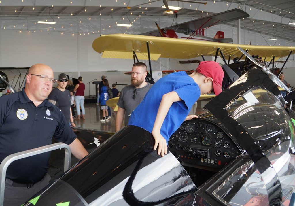 Young boy climbs into the cockpit.